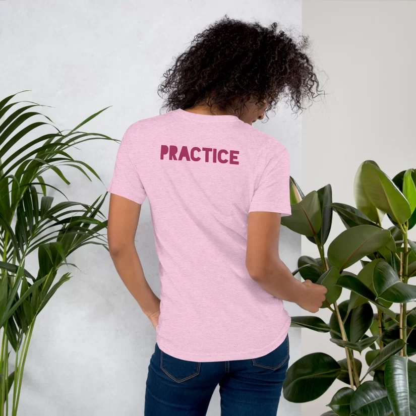 Photo of model showing back of shirt that says PRACTICE.